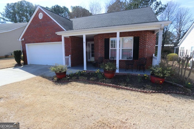 view of front of home with covered porch, concrete driveway, brick siding, and a garage