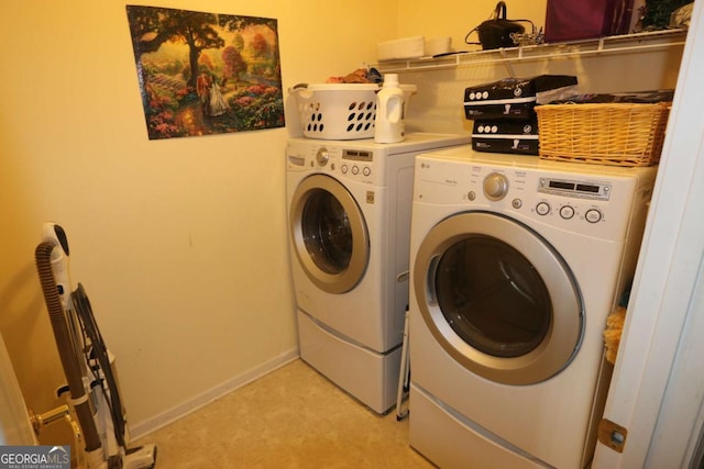 washroom featuring washer and dryer, laundry area, and baseboards