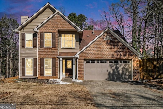 view of front facade featuring aphalt driveway, an attached garage, brick siding, fence, and a chimney