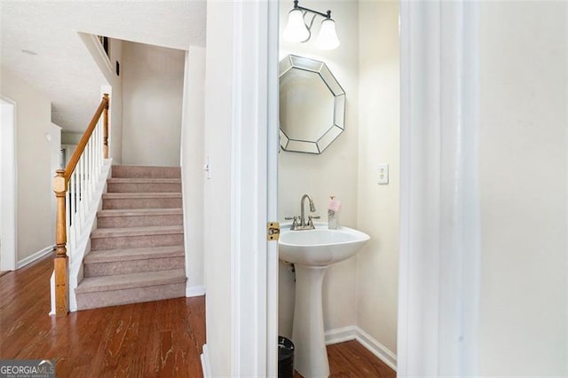 bathroom with a sink, baseboards, and wood finished floors