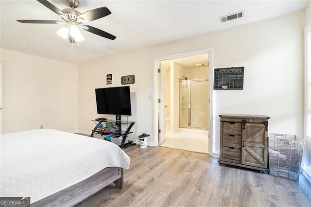 bedroom with ensuite bath, visible vents, ceiling fan, and wood finished floors