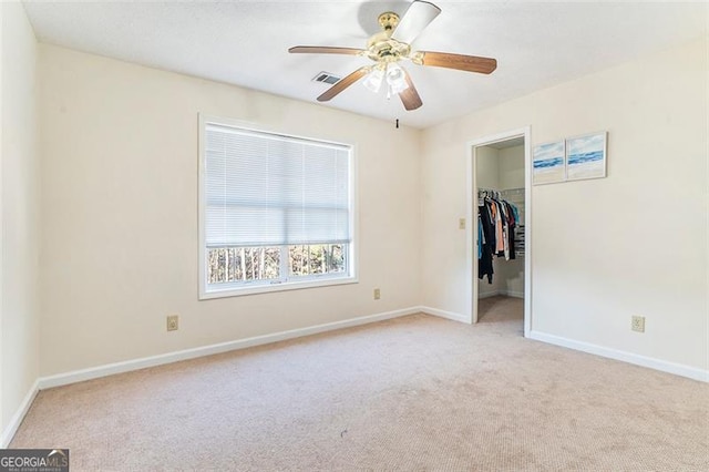 unfurnished bedroom featuring baseboards, visible vents, a spacious closet, carpet floors, and a closet