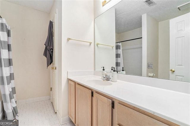 bathroom featuring visible vents, a shower with shower curtain, a textured ceiling, vanity, and tile patterned floors