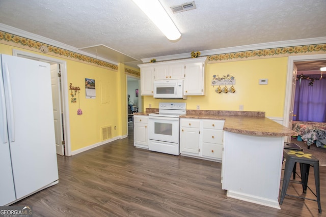 kitchen featuring a peninsula, white appliances, visible vents, and white cabinets