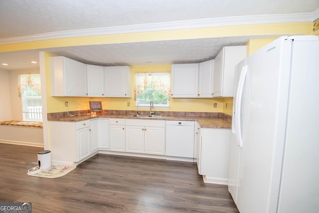 kitchen featuring white appliances, a sink, white cabinets, and crown molding