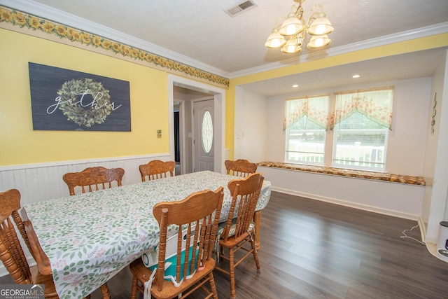 dining room with visible vents, a wainscoted wall, ornamental molding, wood finished floors, and a chandelier