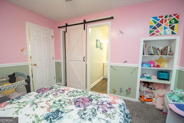 carpeted bedroom with a barn door