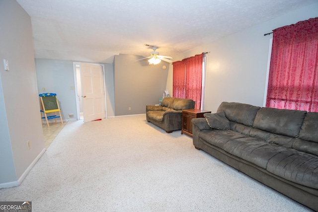 carpeted living area with ceiling fan, a textured ceiling, and baseboards