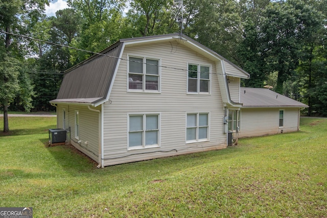 rear view of house featuring a yard, metal roof, cooling unit, and a gambrel roof