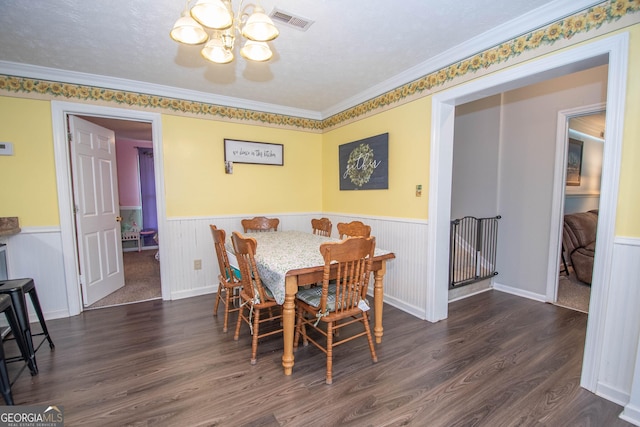 dining area featuring a wainscoted wall, visible vents, and wood finished floors