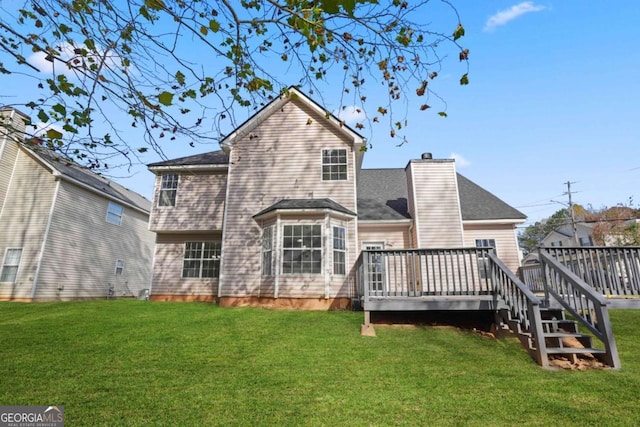 back of property with a deck, a lawn, and a chimney