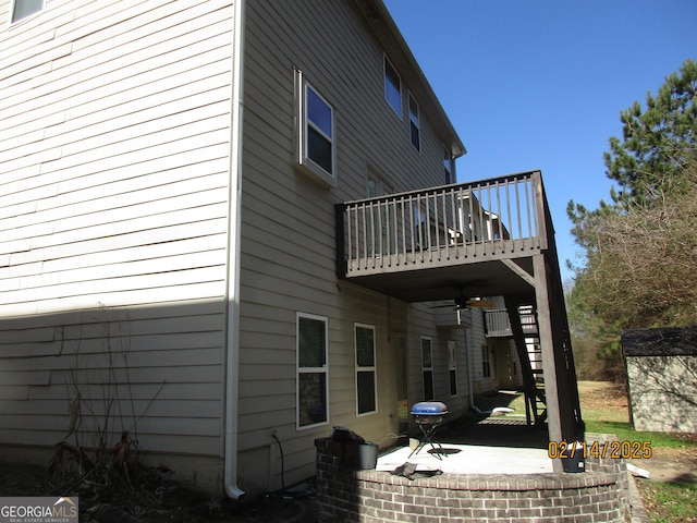 rear view of house with a deck, stairs, and a patio area