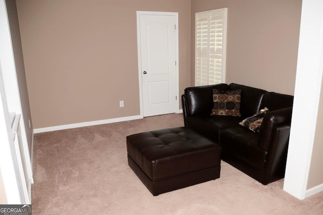 living area with baseboards and carpet