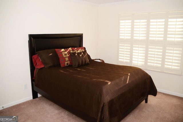 carpeted bedroom with baseboards and ornamental molding