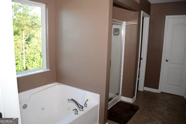 full bath with baseboards, a stall shower, and a whirlpool tub