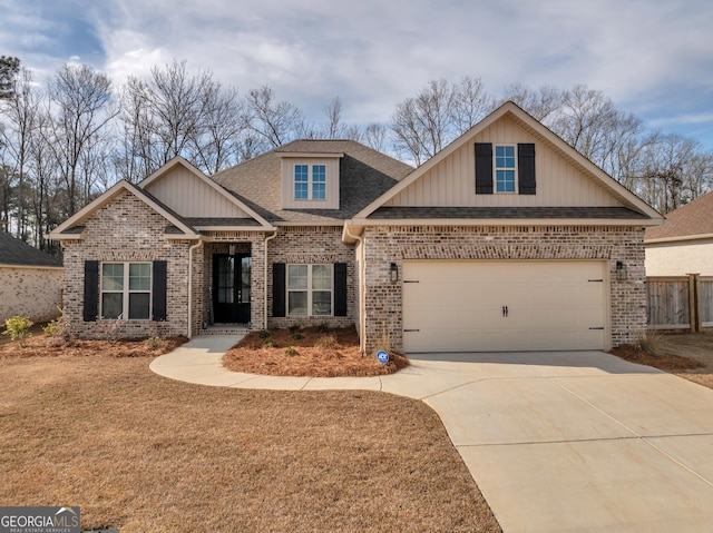 craftsman-style house with a shingled roof, brick siding, and driveway