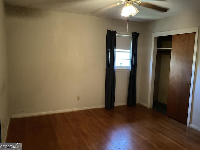 unfurnished bedroom with a closet, ceiling fan, baseboards, and wood finished floors