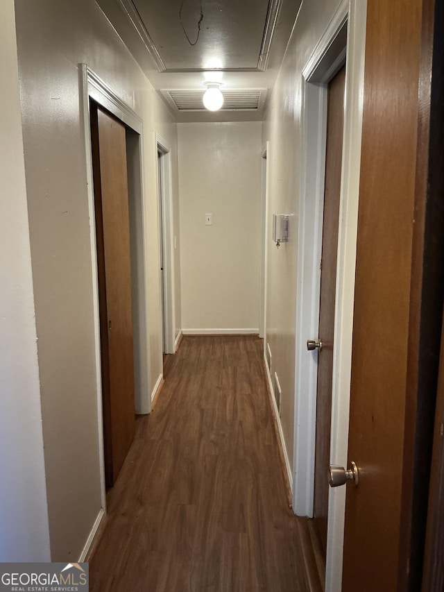 corridor with baseboards, attic access, visible vents, and wood finished floors