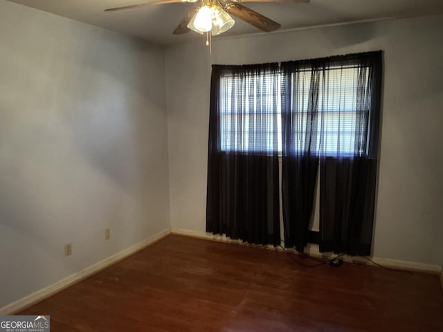 spare room featuring a ceiling fan, baseboards, and wood finished floors