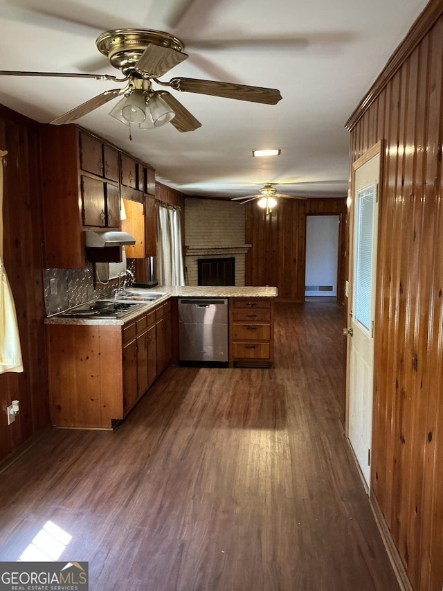 kitchen with dishwasher, brown cabinets, dark wood-type flooring, a peninsula, and a sink