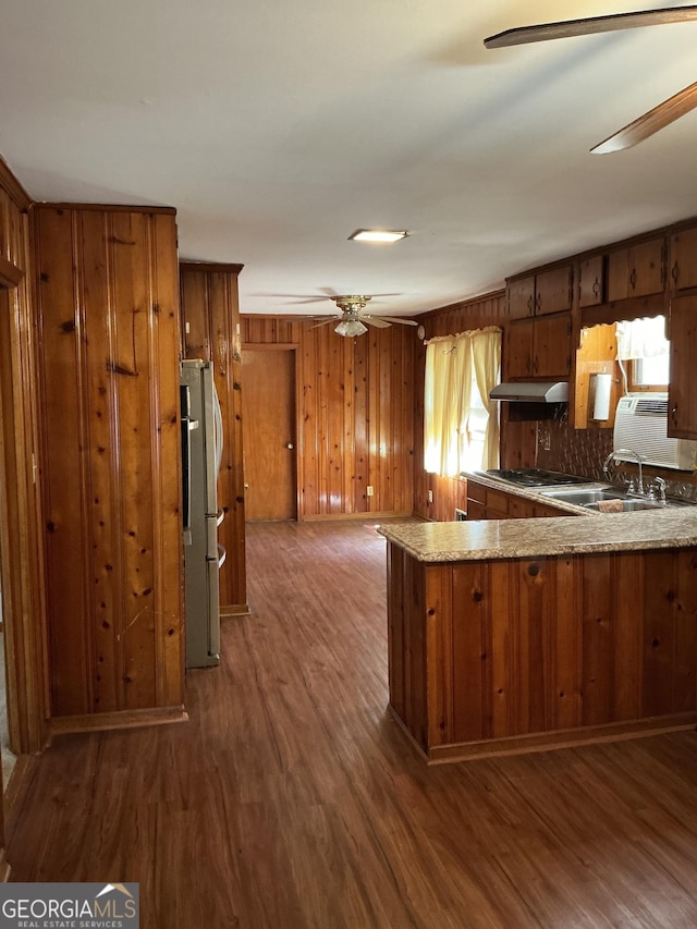 kitchen featuring wood finished floors, brown cabinetry, a ceiling fan, and freestanding refrigerator