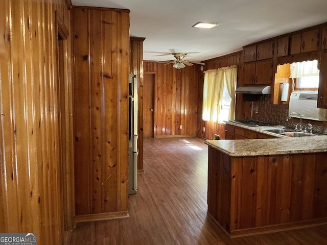 kitchen featuring light wood-style flooring, brown cabinetry, a healthy amount of sunlight, and under cabinet range hood