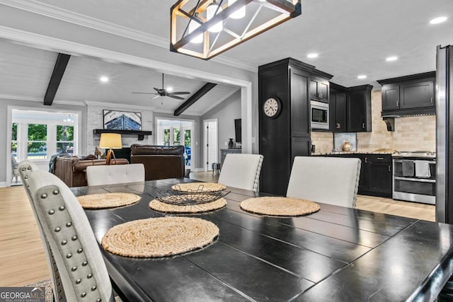 dining area with crown molding, a healthy amount of sunlight, vaulted ceiling with beams, and light wood-style flooring