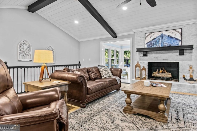 living room featuring vaulted ceiling with beams, ceiling fan, wood finished floors, ornamental molding, and a brick fireplace