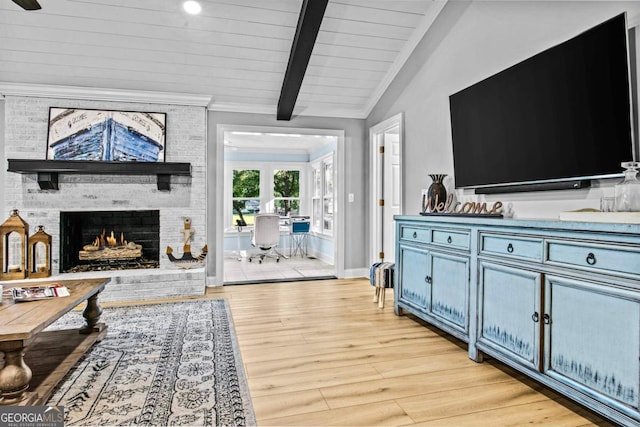 living room featuring baseboards, light wood-style flooring, wood ceiling, vaulted ceiling with beams, and a fireplace