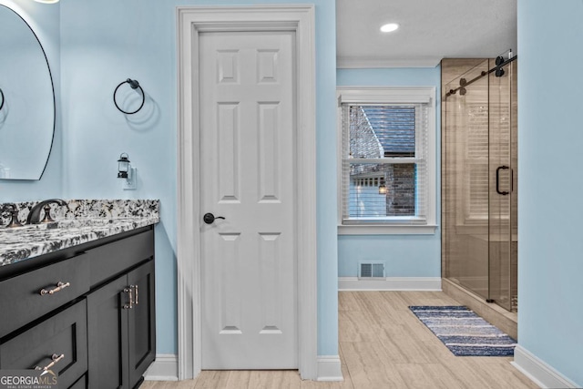 bathroom with a shower stall, visible vents, baseboards, and vanity