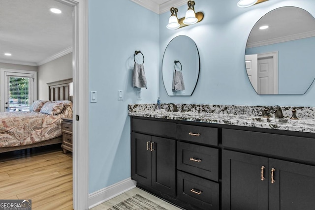 ensuite bathroom with a sink, wood finished floors, ensuite bath, and crown molding