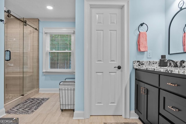 bathroom with ornamental molding, a shower stall, vanity, and baseboards