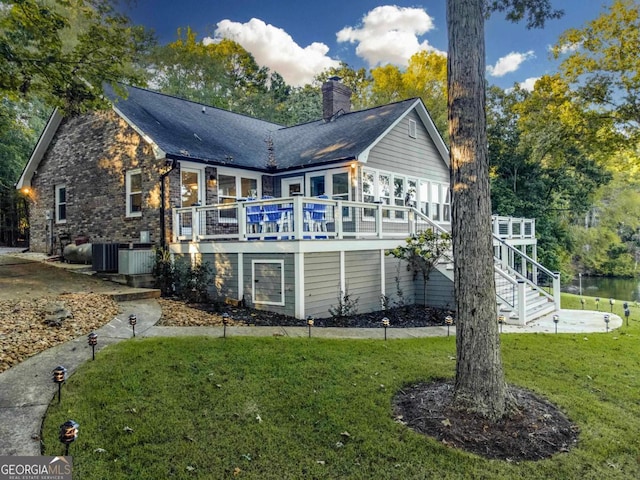 rear view of house featuring a chimney, stairway, a deck, cooling unit, and a yard