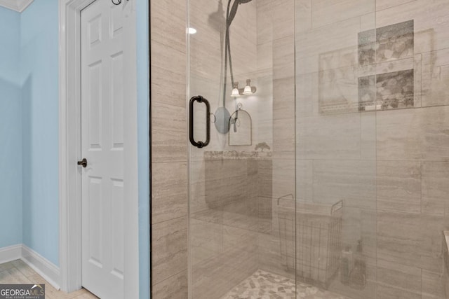 bathroom featuring a stall shower and baseboards