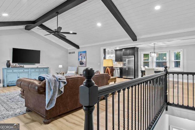 living room featuring lofted ceiling with beams, a ceiling fan, baseboards, light wood-style floors, and ornamental molding