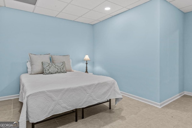 bedroom featuring a drop ceiling and baseboards