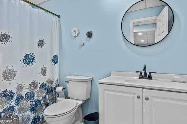 full bathroom featuring a shower with curtain, vanity, and toilet