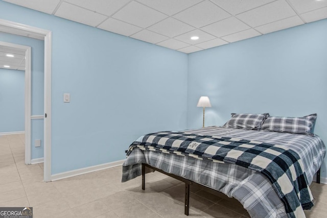 tiled bedroom with baseboards, a drop ceiling, and recessed lighting