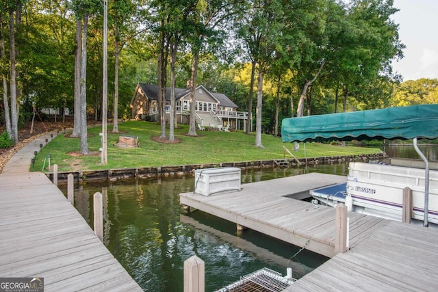 dock area with a water view and a yard