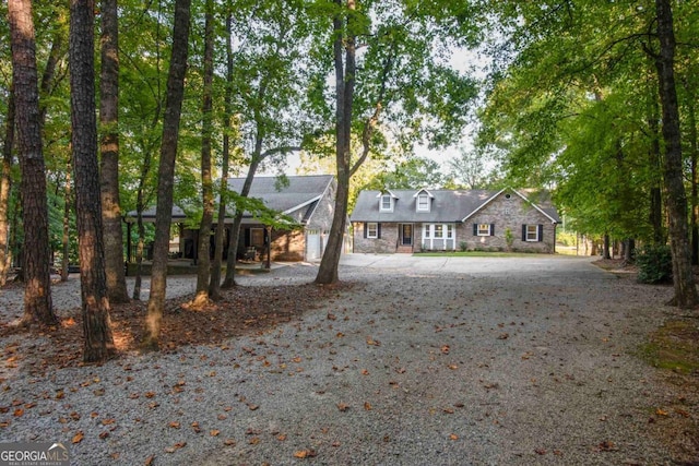 view of front of property with driveway and stone siding