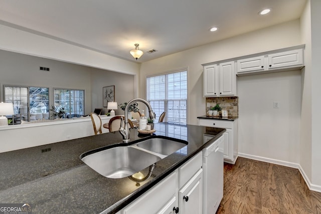 kitchen featuring a sink, visible vents, white cabinetry, dishwasher, and dark wood finished floors