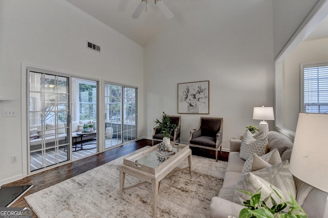 living area featuring ceiling fan, high vaulted ceiling, wood finished floors, and visible vents