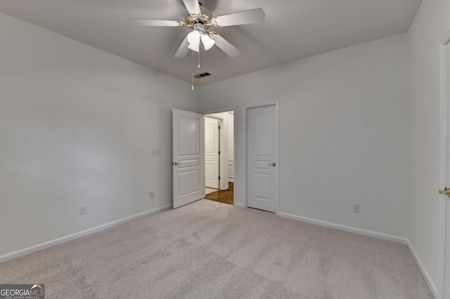 unfurnished bedroom with a ceiling fan, baseboards, visible vents, and carpet flooring