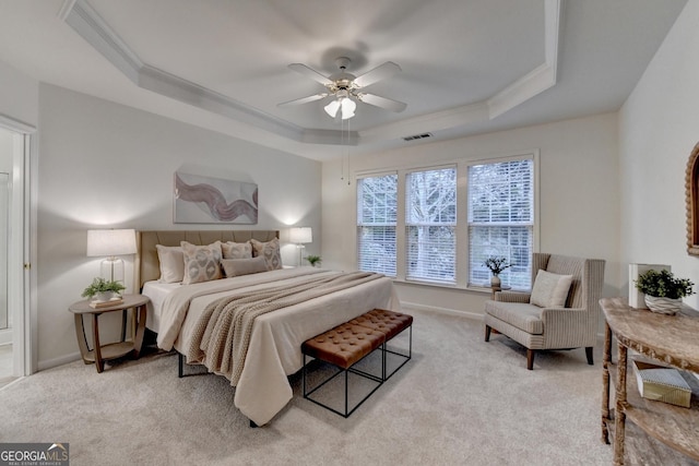 bedroom with light carpet, visible vents, baseboards, a tray ceiling, and crown molding