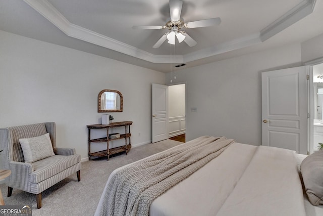 bedroom featuring light colored carpet, visible vents, baseboards, ornamental molding, and a raised ceiling