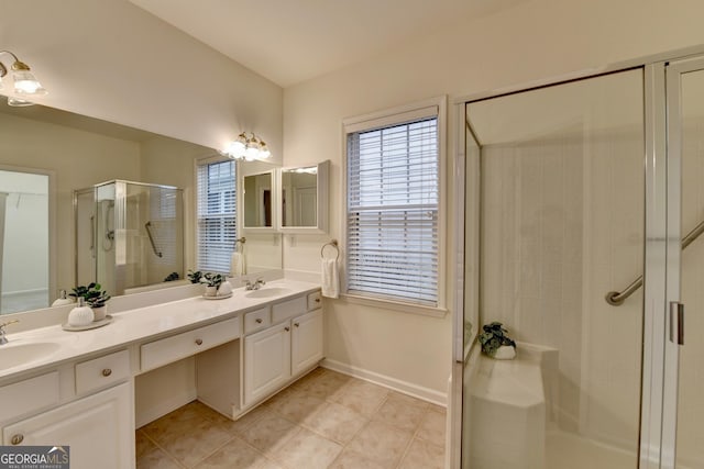 bathroom with double vanity, a stall shower, a sink, and tile patterned floors