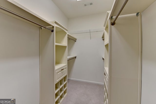 walk in closet with light carpet and visible vents