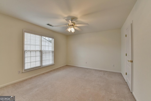 empty room with visible vents, ceiling fan, light carpet, and baseboards