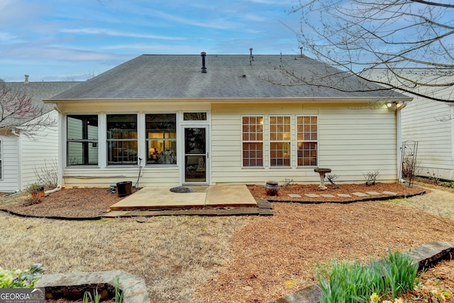 back of house featuring roof with shingles and a patio