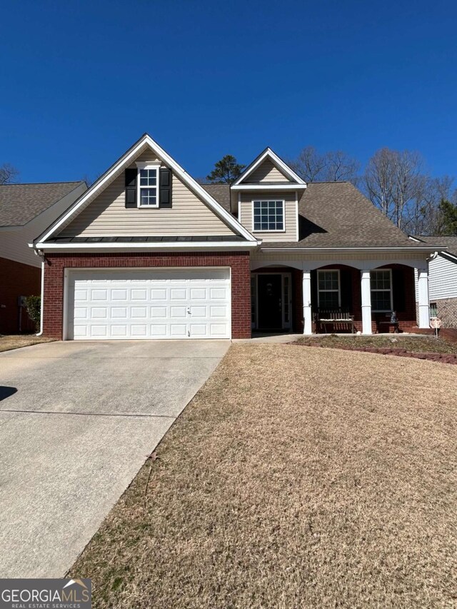 view of front of house with brick siding, roof with shingles, covered porch, concrete driveway, and a garage